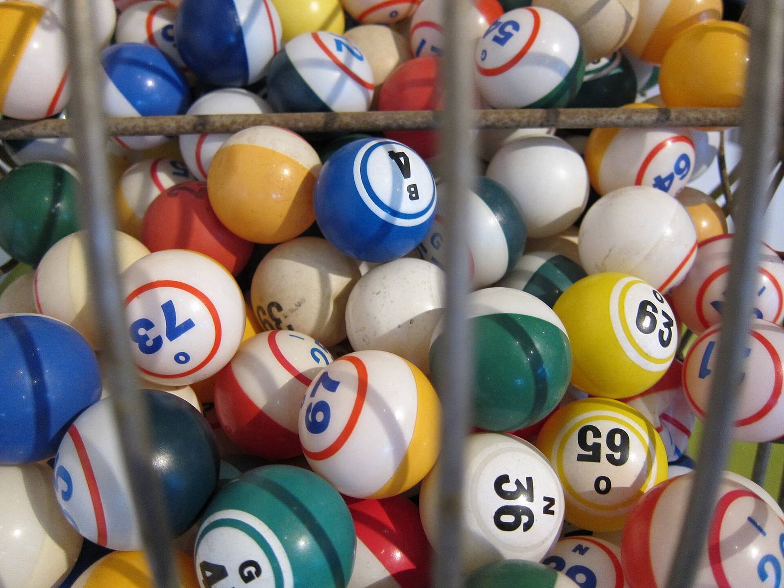 Numbered bingo balls inside a wire bingo drum