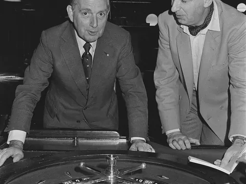 Dois homens junto a uma roda de roleta num casino